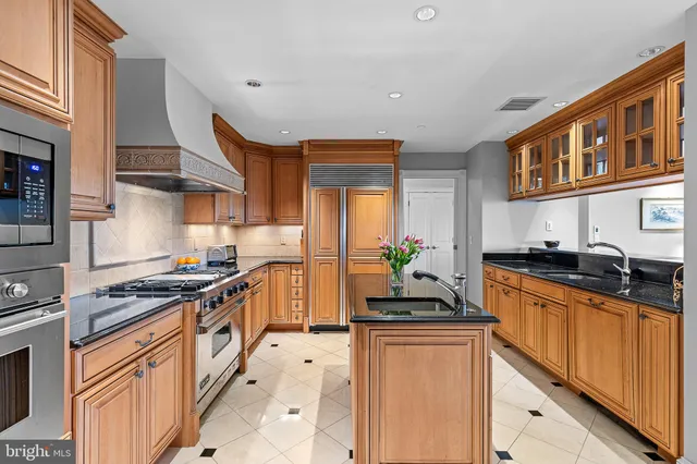 a kitchen with stainless steel appliances granite countertop a stove a sink and a refrigerator