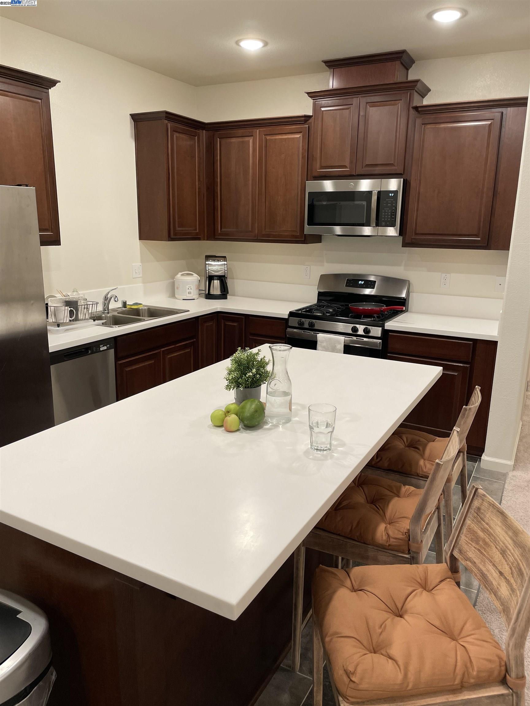 4246 Freemark Avenue Merced, CA 95348 - Photo 14 of 27 a kitchen with a sink a stove and a wooden cabinets