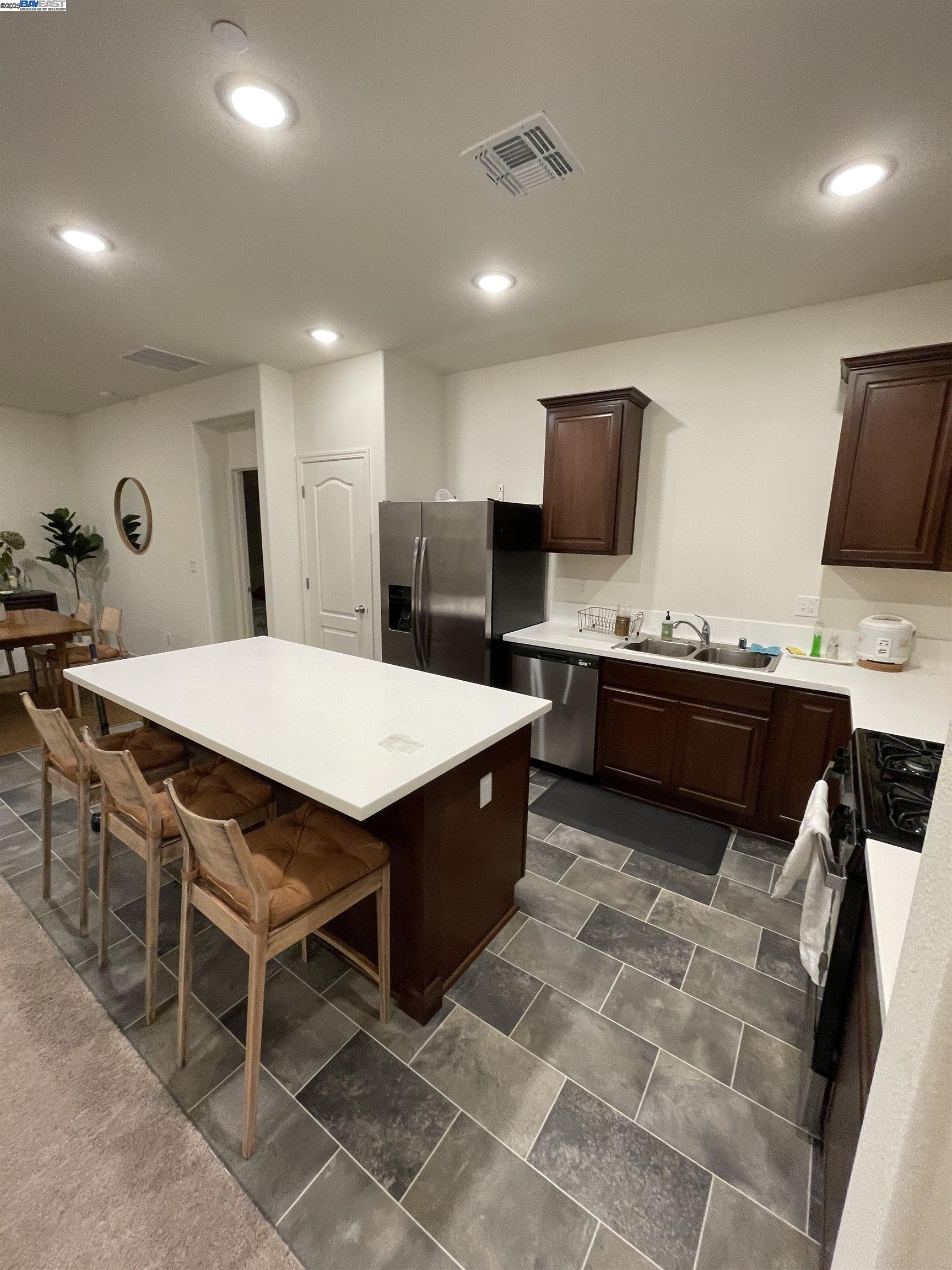 4246 Freemark Avenue Merced, CA 95348 - Photo 15 of 27 a kitchen with stainless steel appliances kitchen island granite countertop a sink a stove a counter top space and cabinets