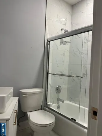 a white toilet sitting next to a bath tub