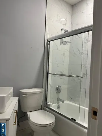 a white toilet sitting next to a bath tub