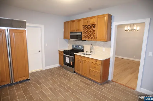 a kitchen with stainless steel appliances granite countertop a stove a sink and a refrigerator