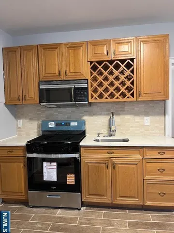a kitchen with granite countertop a stove top oven microwave and cabinets