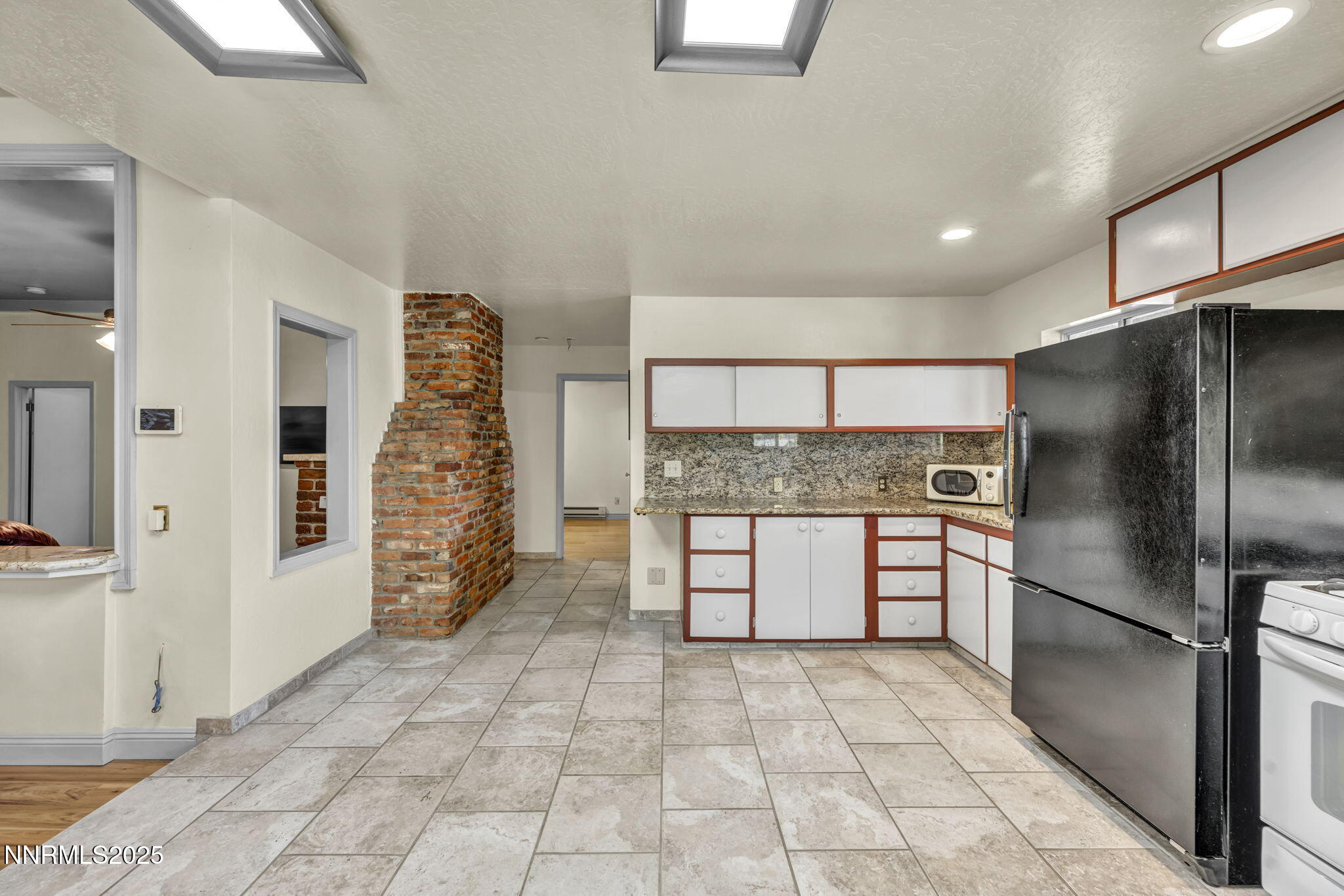 100 Pedlar Road Silver City, NV 89428 - Photo 22 of 65 a kitchen with granite countertop a refrigerator and a stove top oven