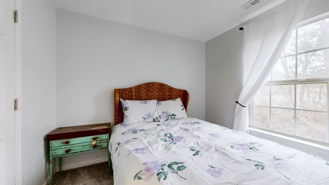 a bedroom with a bed and a window