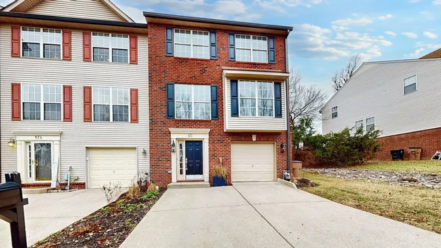 a view of a building with car parked on the roadside
