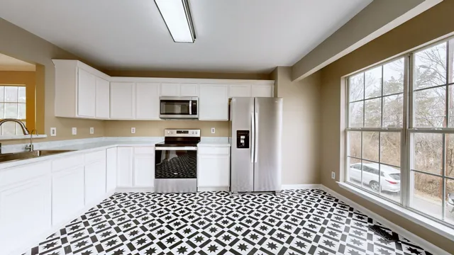 a view of a kitchen with an empty space and a window