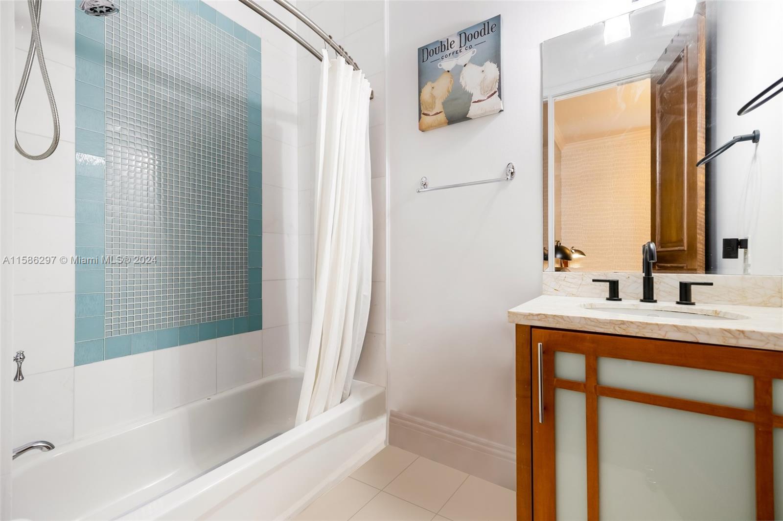 200 Ridgewood Road Coral Gables, FL 33133 - Photo 41 of 70 a bathroom with a bath tub sitting next to a white sink and a mirror next to a window