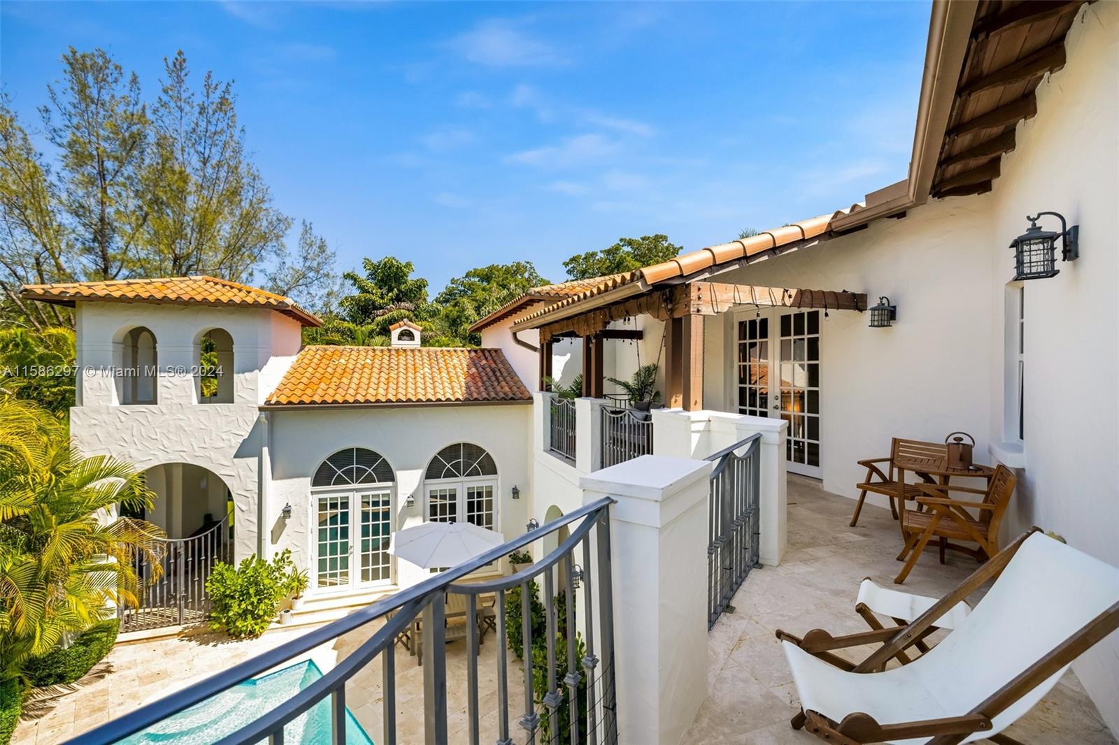 200 Ridgewood Road Coral Gables, FL 33133 - Photo 54 of 70 a view of a white house with large windows and couches chairs