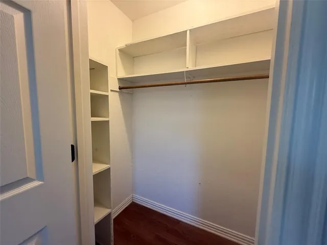 a room with walk in closet with wooden floor