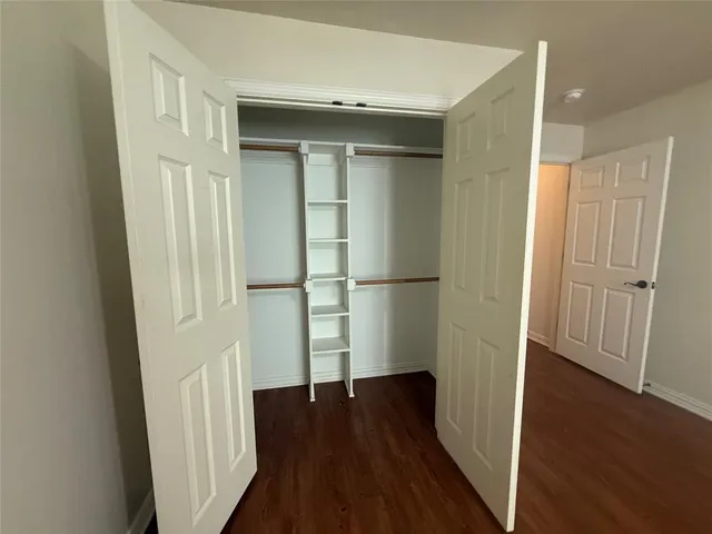 an empty room with wooden floor and entrance