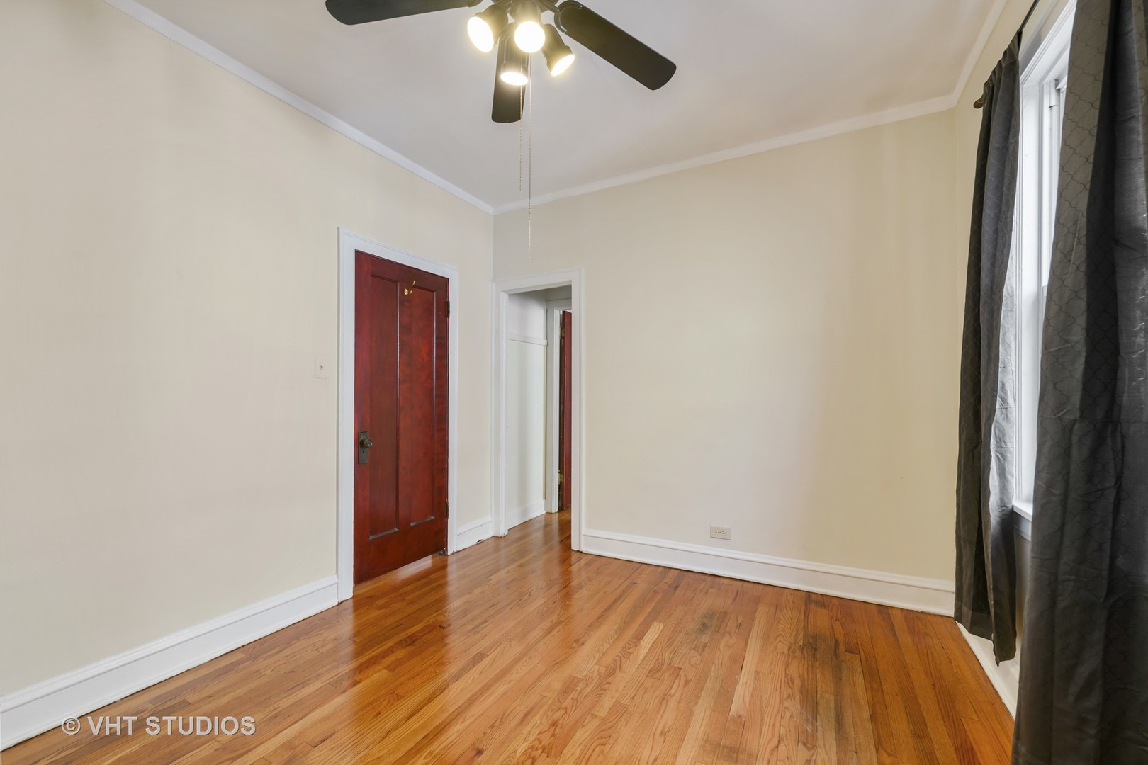 2736 North Harding Avenue, Unit 2 Chicago, IL 60647 - Photo 8 of 12 an empty room with wooden floor and chandelier fan