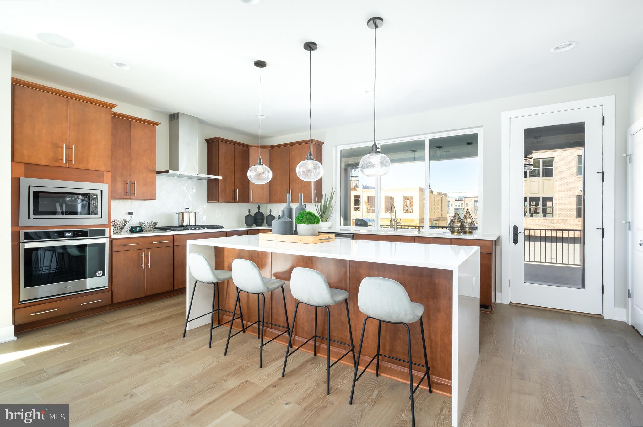 a kitchen with stainless steel appliances granite countertop wooden floor window and cabinets