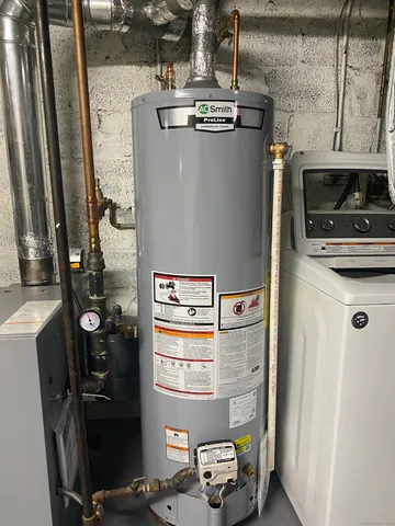 a room with water heater and wooden cabinets