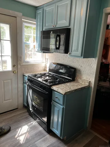 a kitchen with granite countertop a stove and a microwave