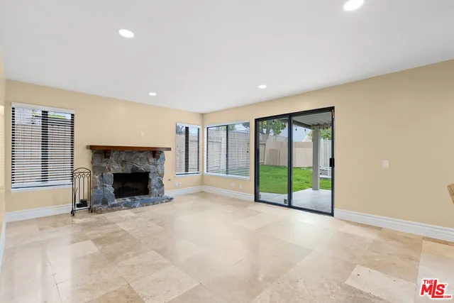 a view of an empty room with a fireplace and a window