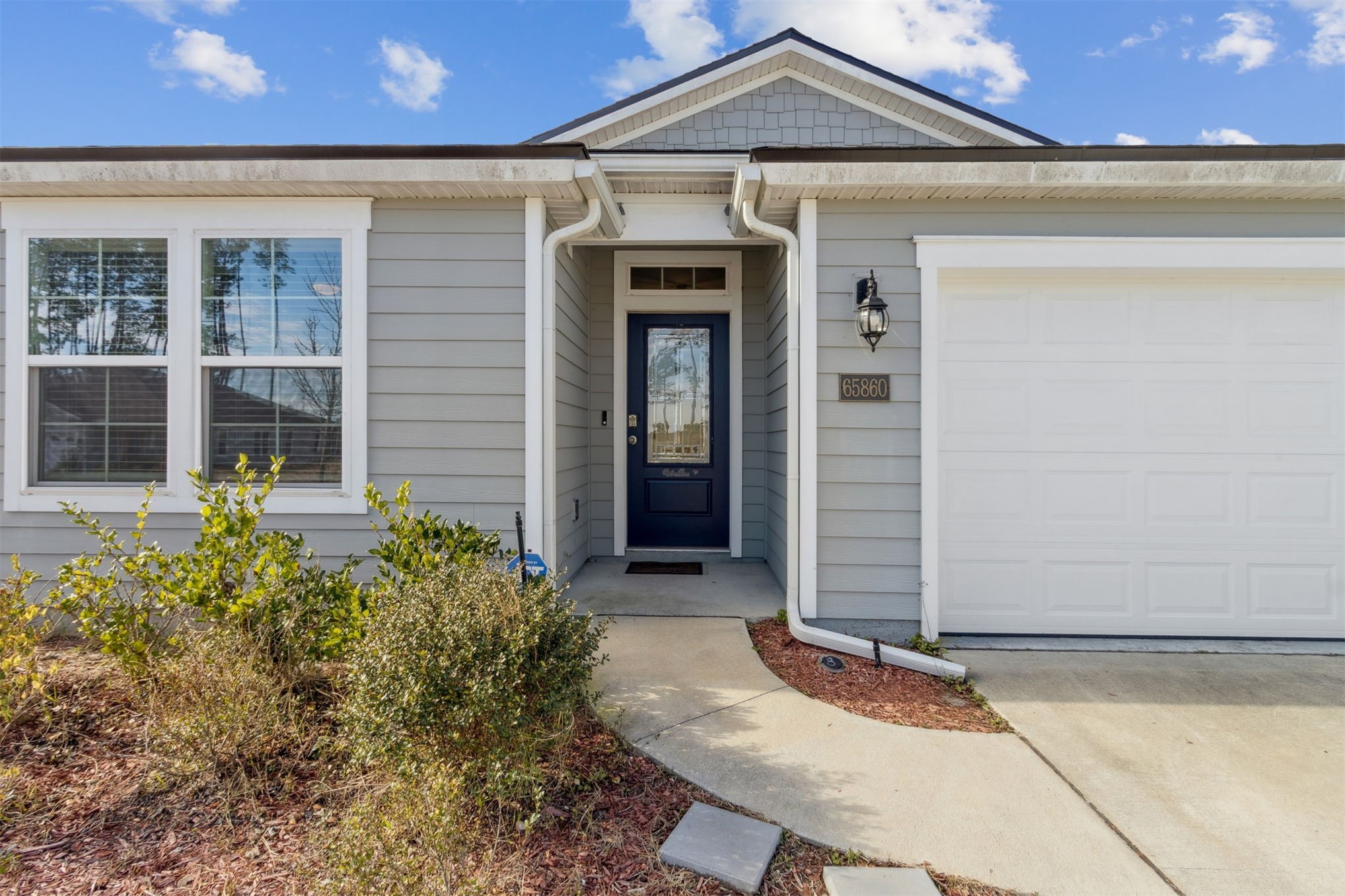 65860 Edgewater Drive Yulee, FL 32097 - Photo 11 of 39 a front view of a house with garden