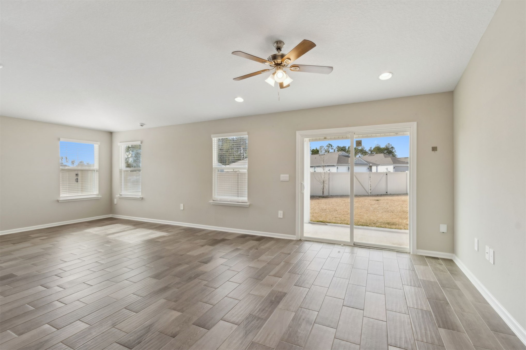 65860 Edgewater Drive Yulee, FL 32097 - Photo 14 of 39 an empty room with wooden floor and windows