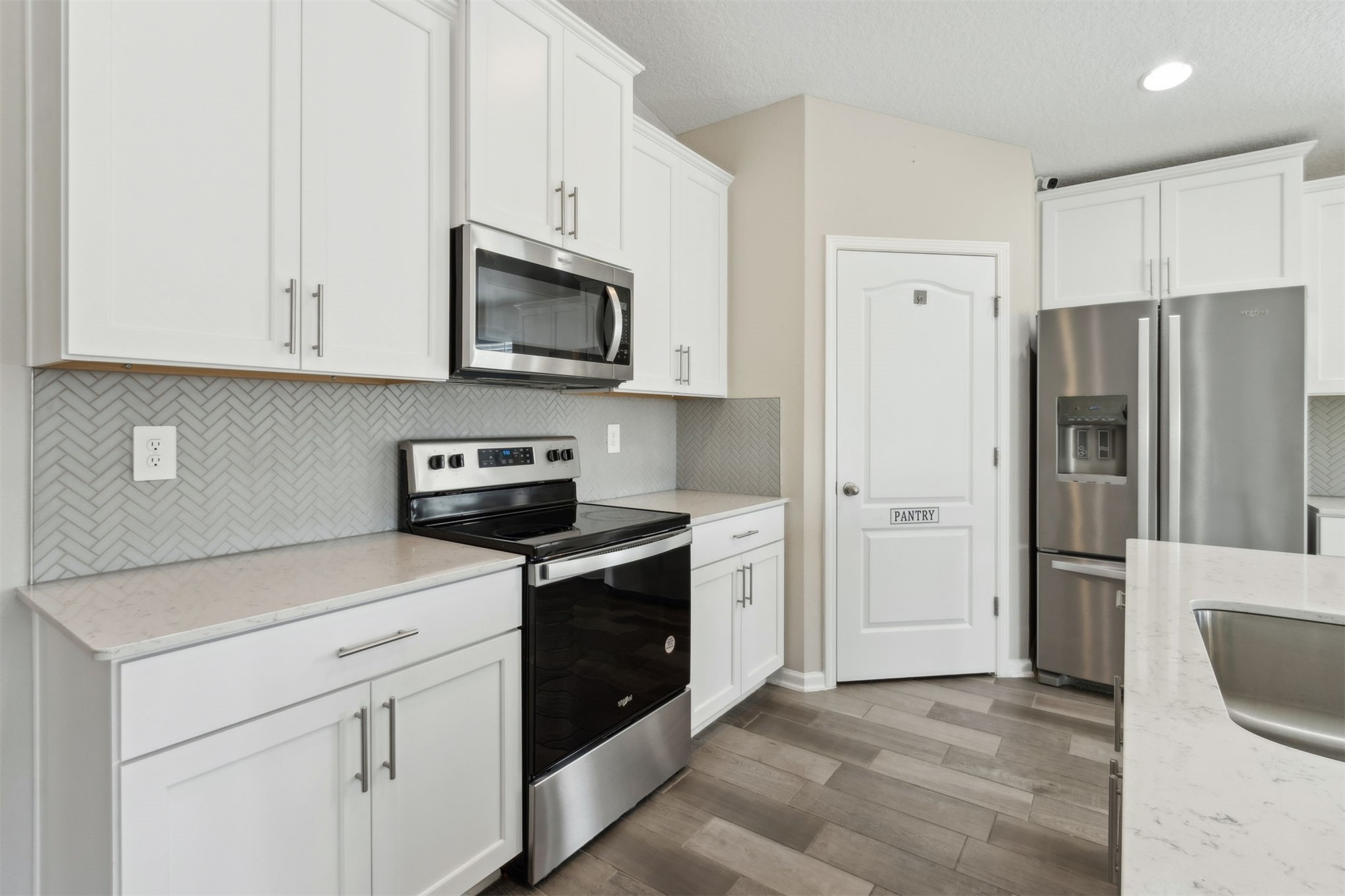 65860 Edgewater Drive Yulee, FL 32097 - Photo 19 of 39 a kitchen with stainless steel appliances granite countertop a refrigerator stove and white cabinets