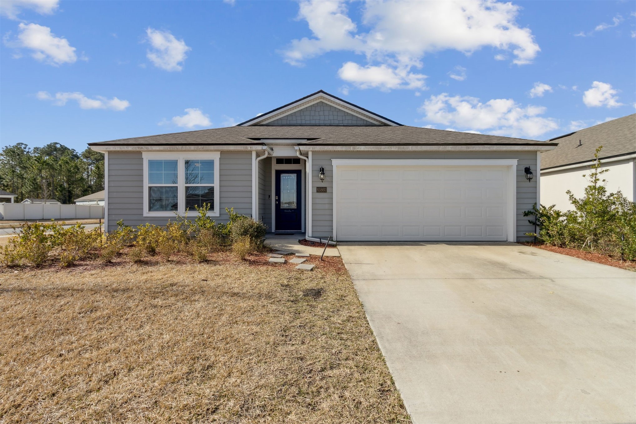 65860 Edgewater Drive Yulee, FL 32097 - Photo 29 of 39 a front view of a house with a yard and garage