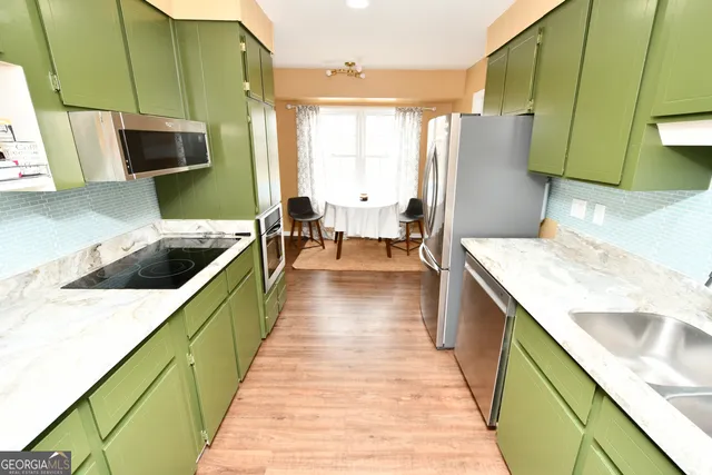 a kitchen with stainless steel appliances granite countertop a sink dishwasher stove and refrigerator