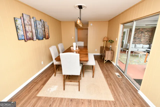 a dining room with furniture a chandelier and wooden floor