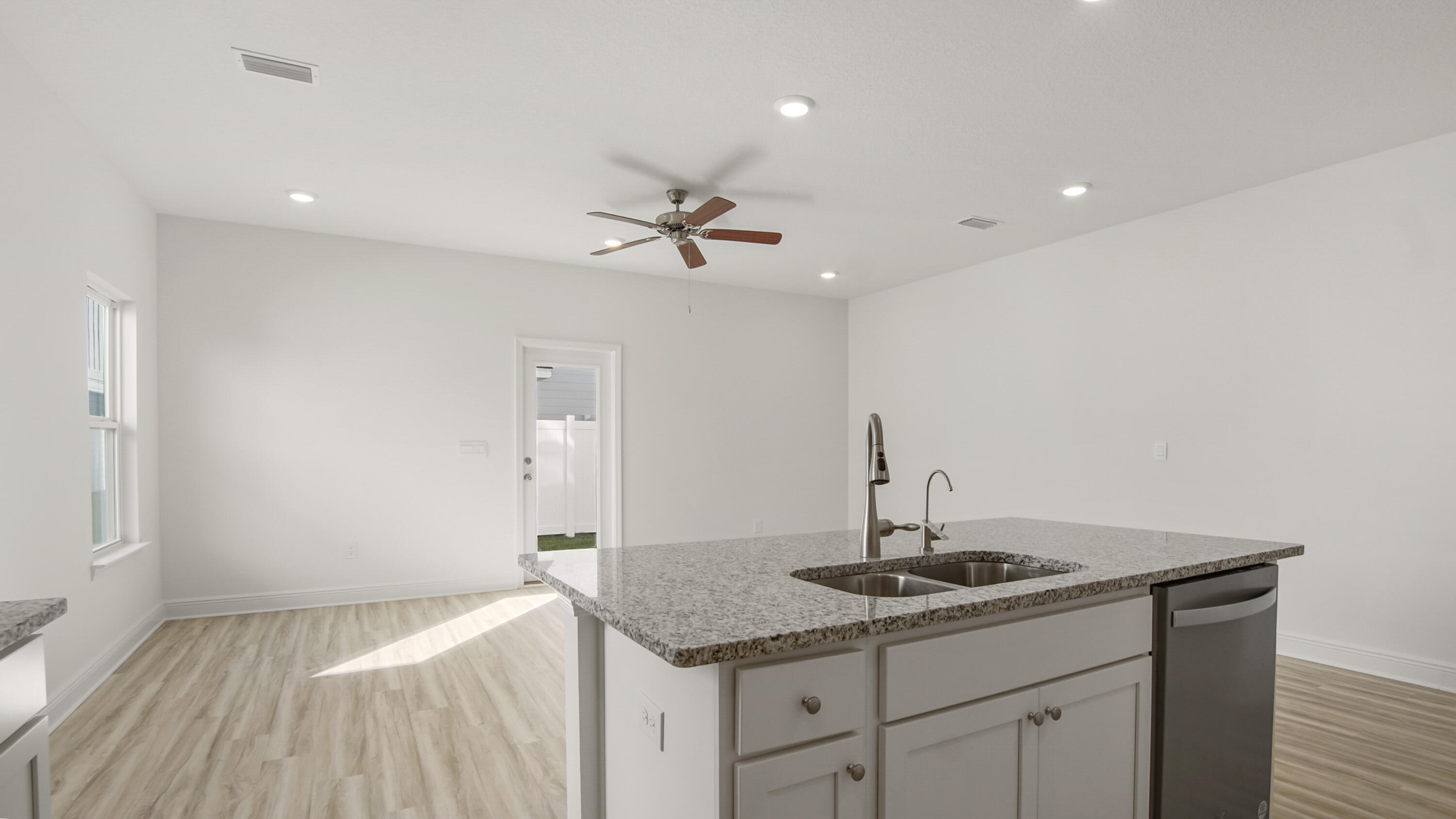 44 Phoenix Street Santa Rosa Beach, FL 32459 - Photo 11 of 37 a kitchen with a sink dishwasher and white cabinets with wooden floor