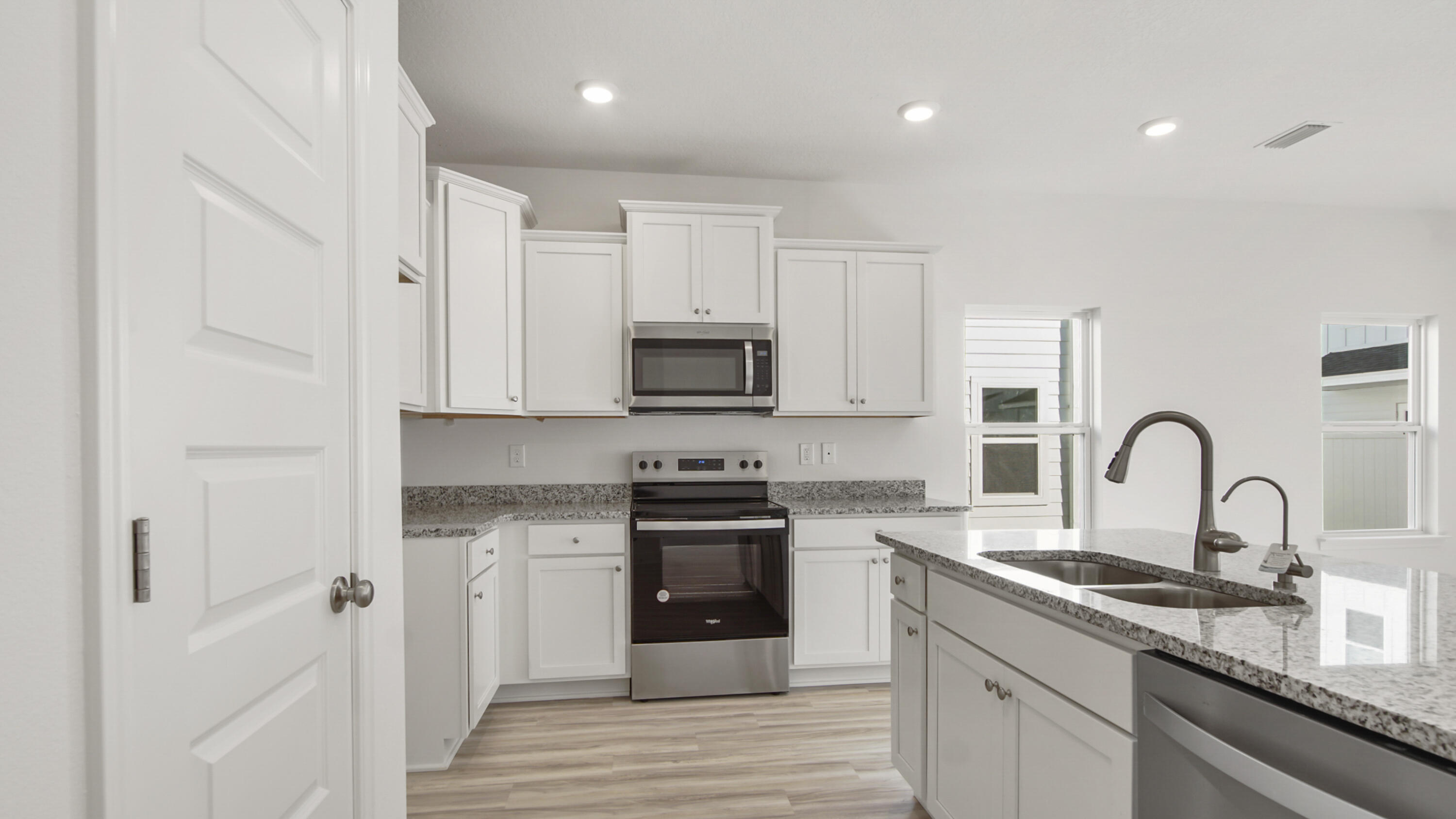 44 Phoenix Street Santa Rosa Beach, FL 32459 - Photo 10 of 37 a kitchen with white cabinets a sink and stainless steel appliances