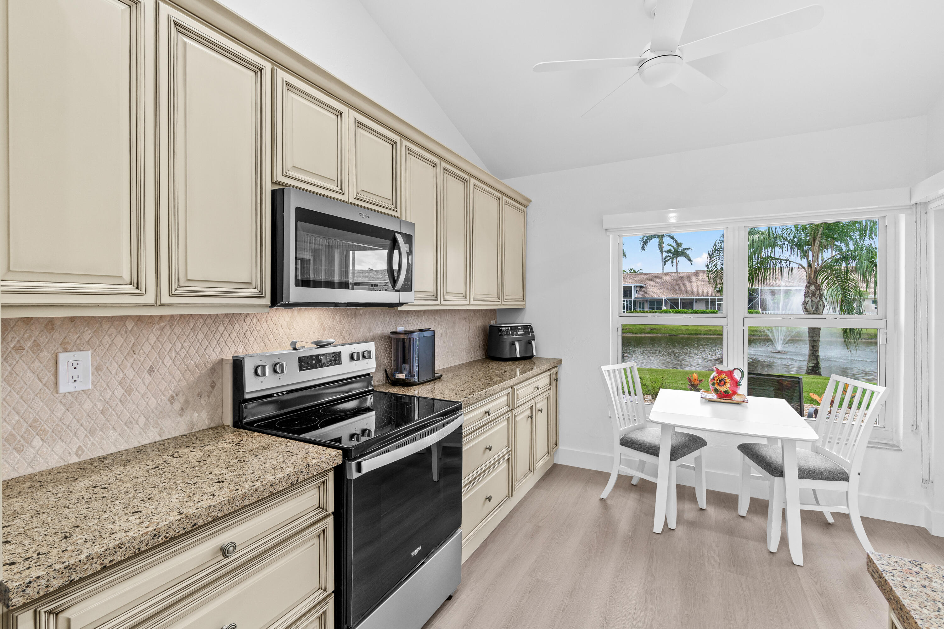 5097 Windsor Parke Drive Boca Raton, FL 33496 - Photo 11 of 27 a kitchen with stainless steel appliances granite countertop a stove top oven a sink dishwasher and white cabinets with wooden floor
