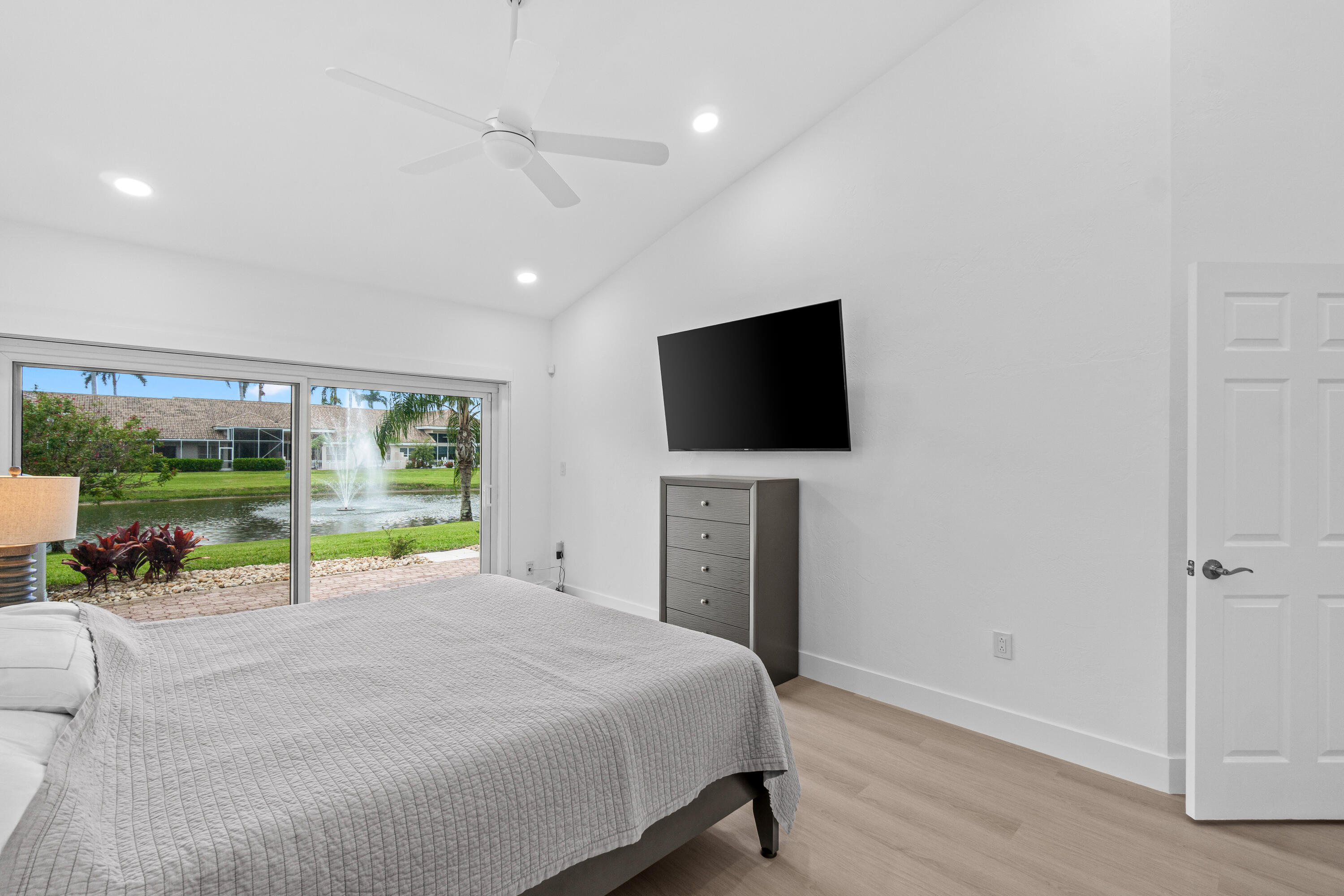 5097 Windsor Parke Drive Boca Raton, FL 33496 - Photo 18 of 27 a bed room with a bed television and a large window