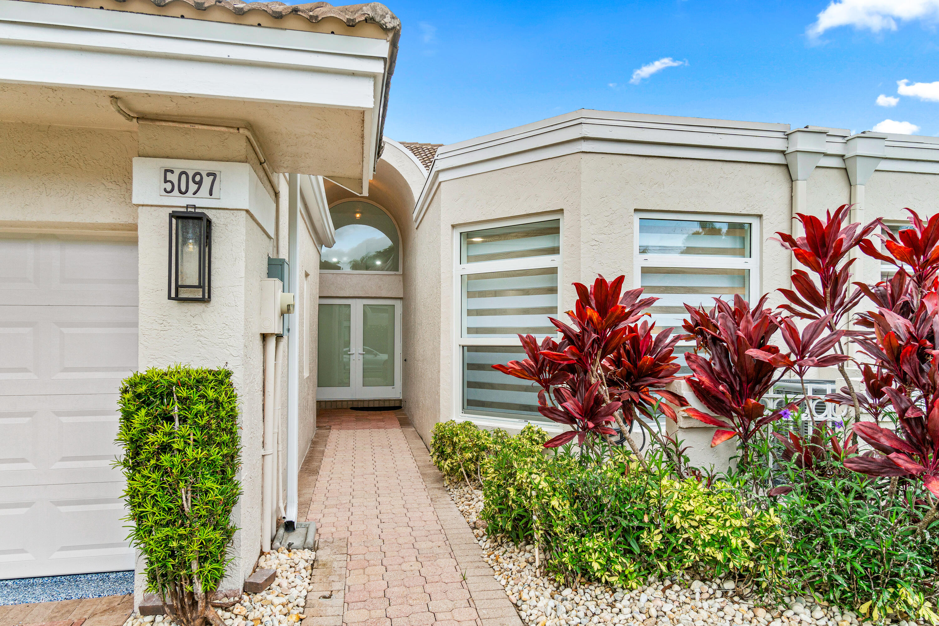 5097 Windsor Parke Drive Boca Raton, FL 33496 - Photo 27 of 27 a front view of a house with lots of flowers