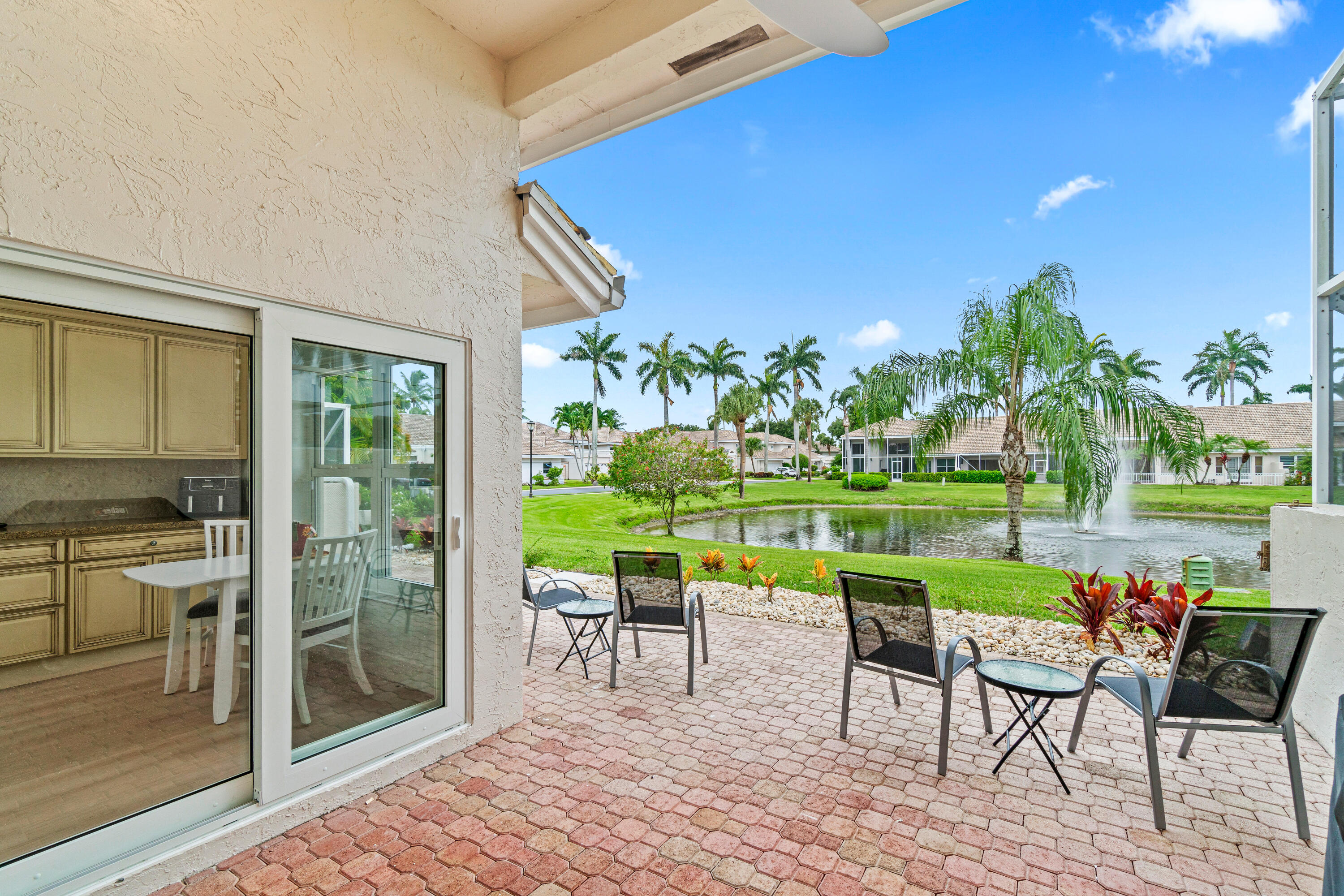 5097 Windsor Parke Drive Boca Raton, FL 33496 - Photo 9 of 27 a view of a chairs and table in patio with a lake view