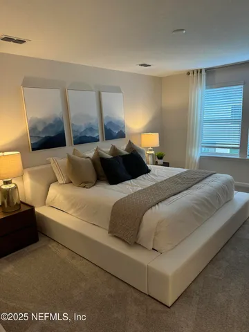 a bedroom with a large bed and a night stand