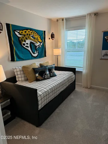 a bedroom with a bed and a painting on the wall