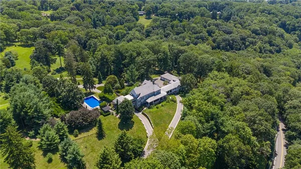an aerial view of a house with a yard and swimming pool