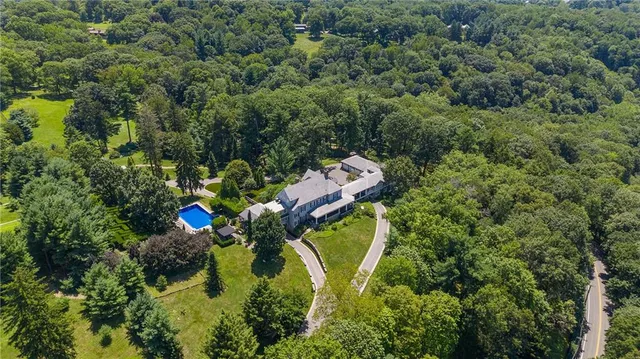 an aerial view of a house with a yard and swimming pool