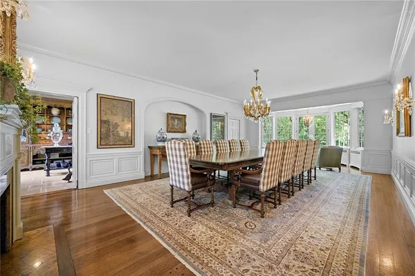 a dining room with wooden floor and a rug