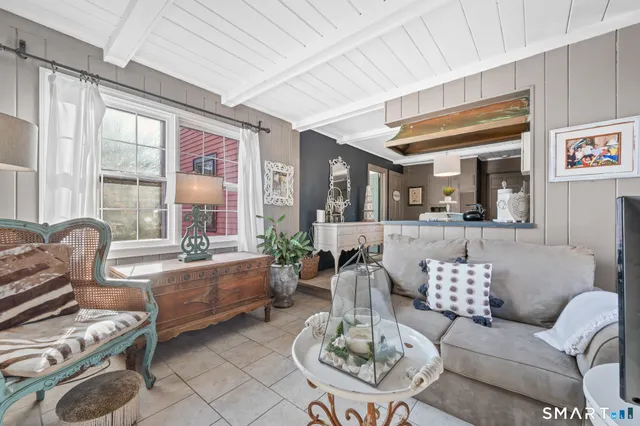 a living room with furniture kitchen view and large windows