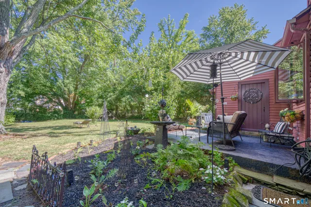 a view of a chair and table in backyard of the house