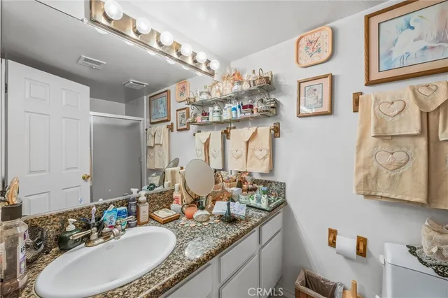 a bathroom with a granite countertop sink a mirror and a shower