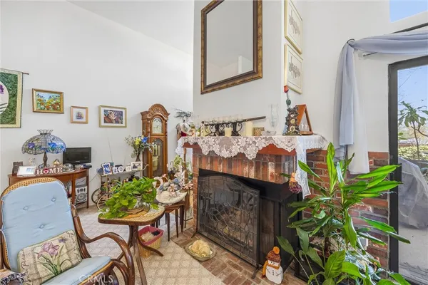 a living room with fireplace furniture and a potted plant