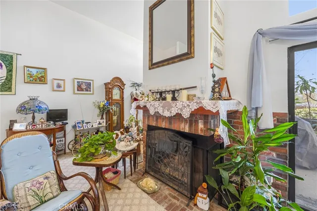 a living room with fireplace furniture and a potted plant