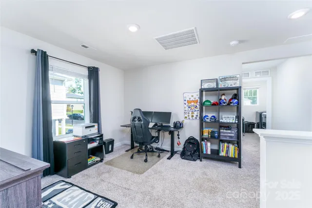 a view of a workspace with furniture and a window
