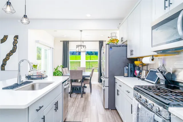 a kitchen with stainless steel appliances a stove a sink a refrigerator and a refrigerator