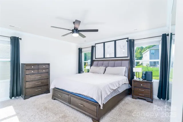 a bedroom with a bed a dresser and a chandelier