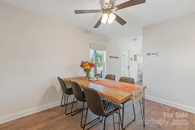 a kitchen with stainless steel appliances granite countertop a refrigerator a stove a sink a table and chairs