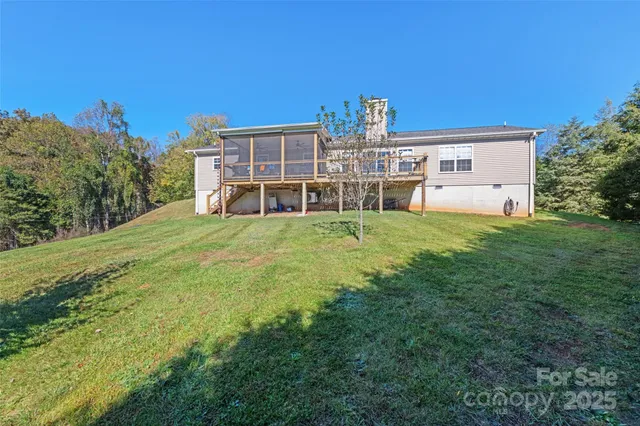 a view of a house with a big yard and large trees