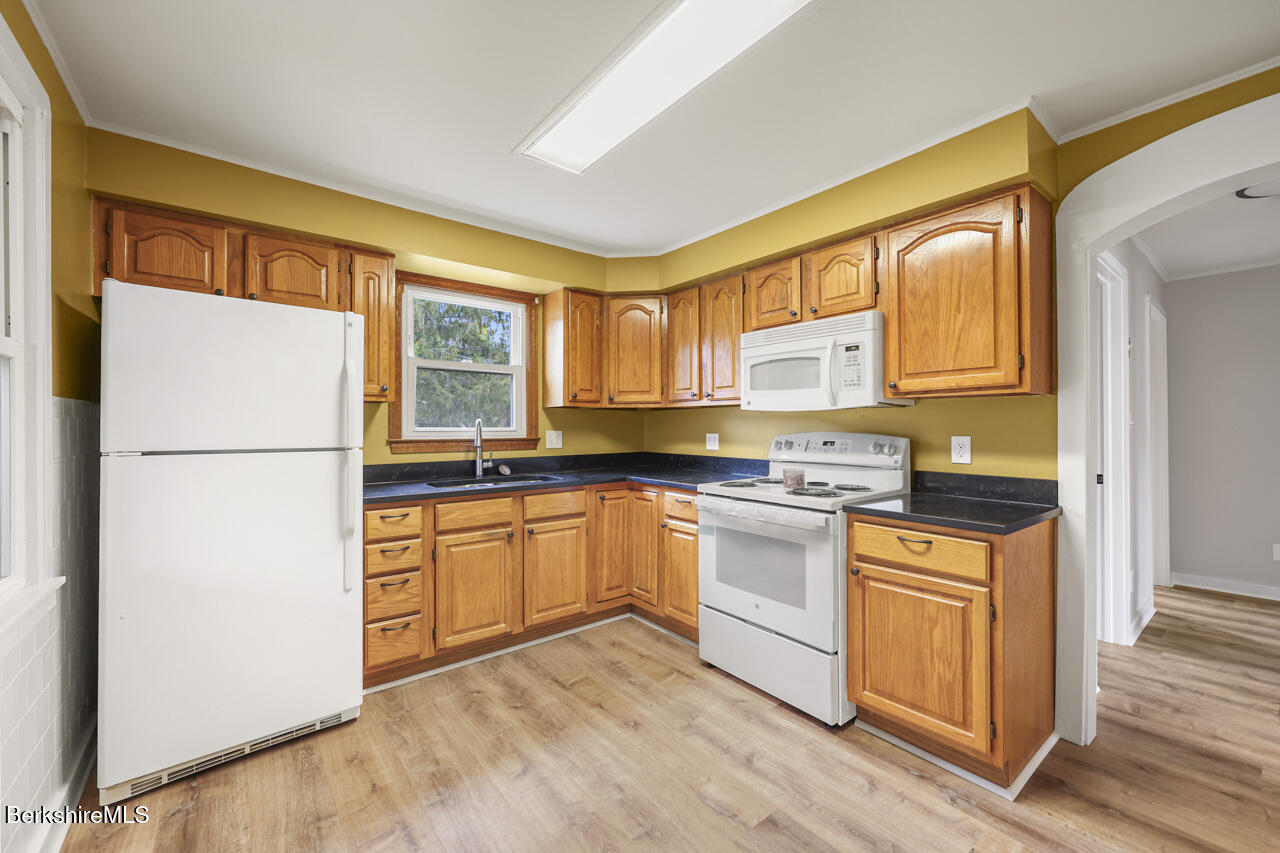 227 Protection Avenue North Adams, MA 01247 - Photo 12 of 25 a kitchen with stainless steel appliances granite countertop a refrigerator a stove a sink and a microwave
