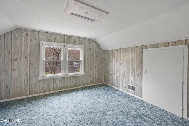 an aerial view of a house with a garden and lake view