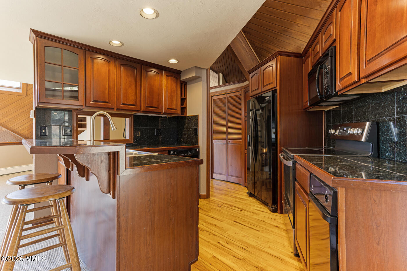1400 Lions Ridge Loop, Unit A1 Vail, CO 81657 - Photo 12 of 41 a kitchen with stainless steel appliances granite countertop a refrigerator a stove and a wooden cabinets